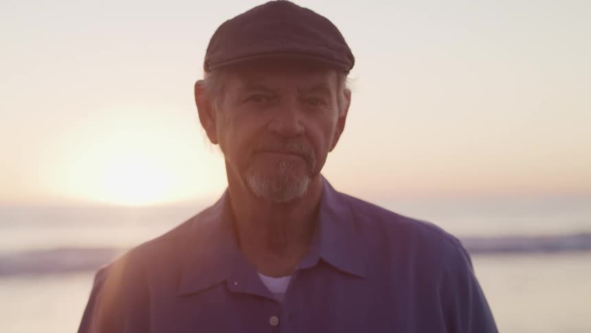 A man is standing outdoors at sunset