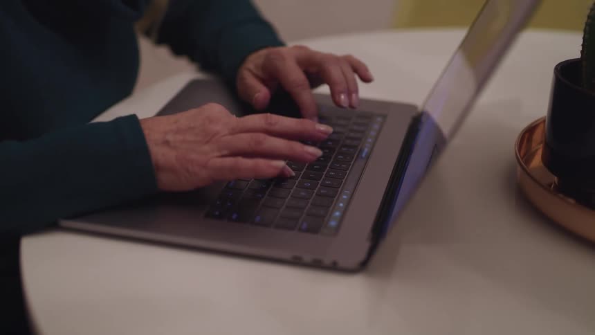 A woman sitting at home uses her laptop