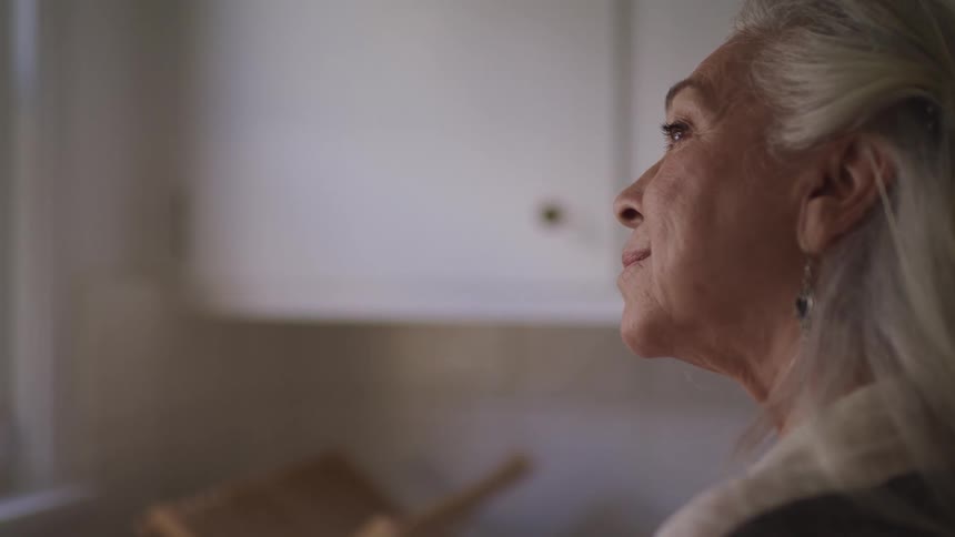 Side view of an elderly woman with grey hair smiling