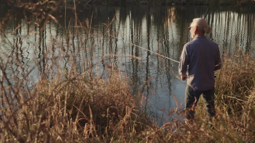 A man standing on the shore fishing