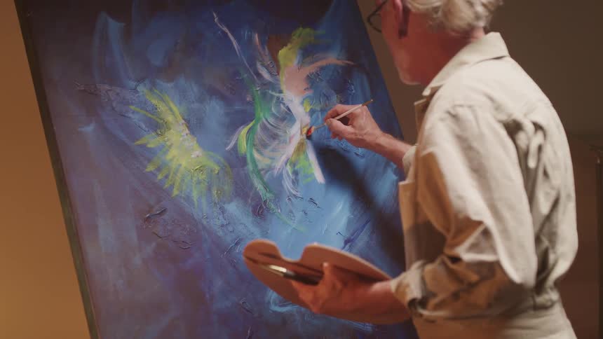 An elderly man is painting a picture