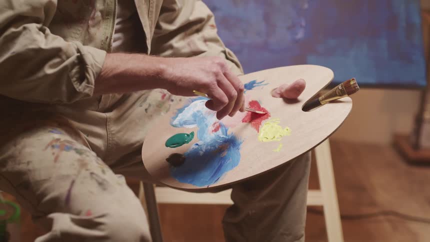 A man mixing paint on a palette