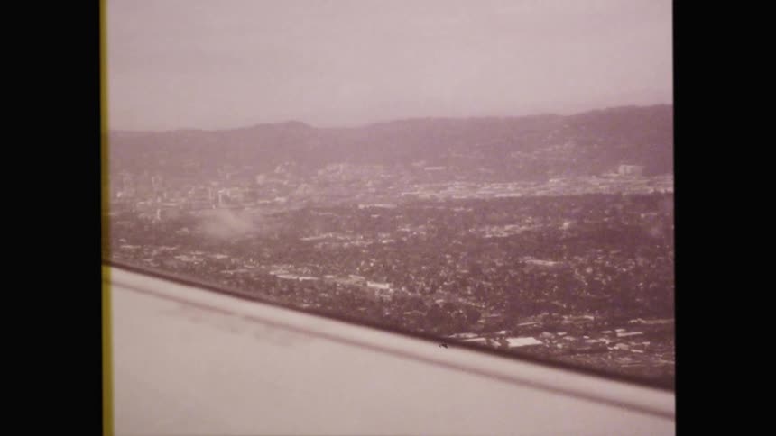 An airplane wing flying in the sky with clouds