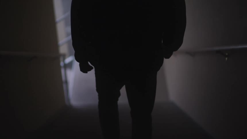 Man in silhouette goes down the stairs
