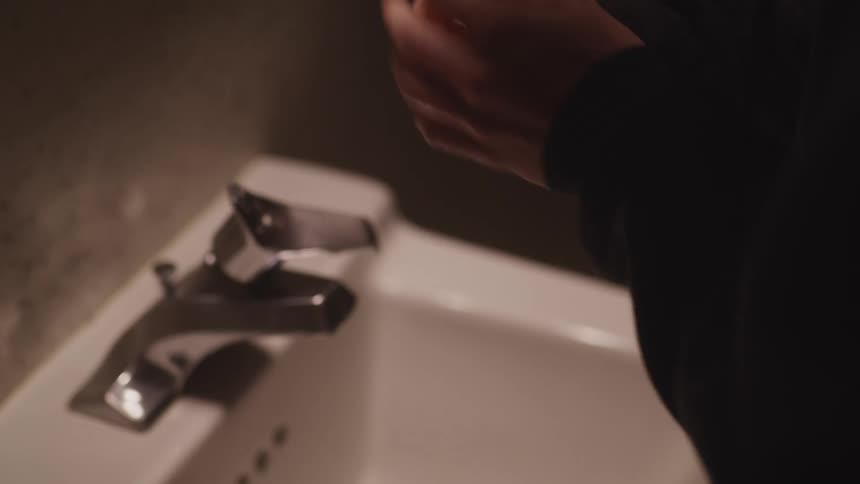 A person is taking medicine in the bathroom