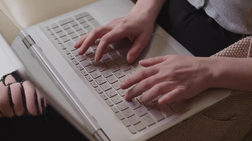 A person is typing on their laptop