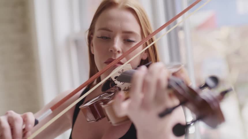 Woman with long hair plays the violin