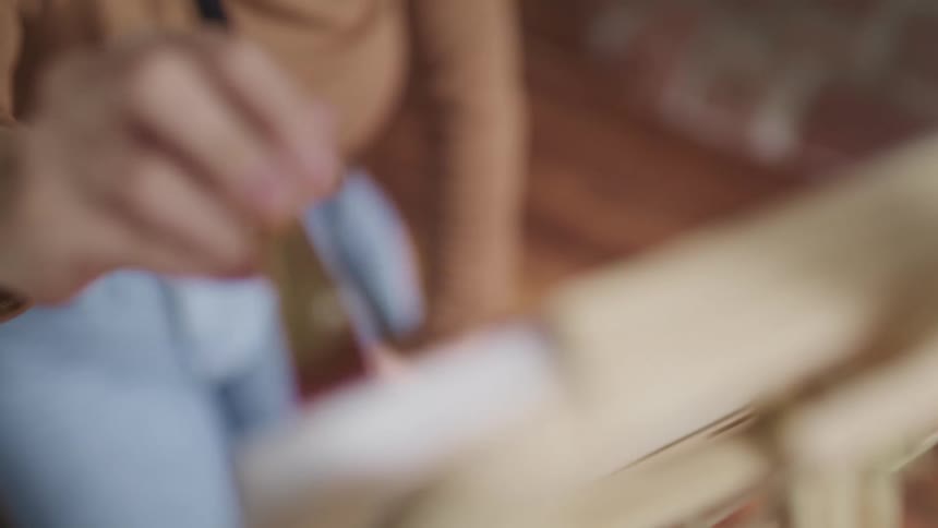 A woman is sitting as she paints