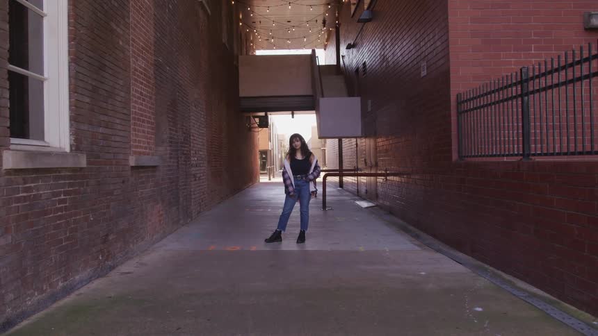 A teenage girl standing in a corridor outside