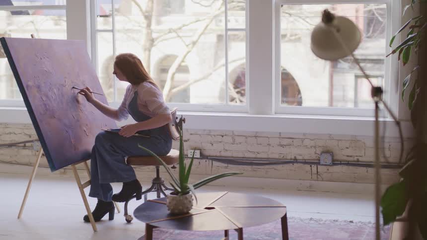 A woman is paiting a picture indoors