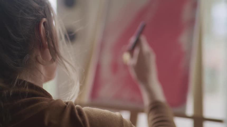A woman is painting a picture indoors