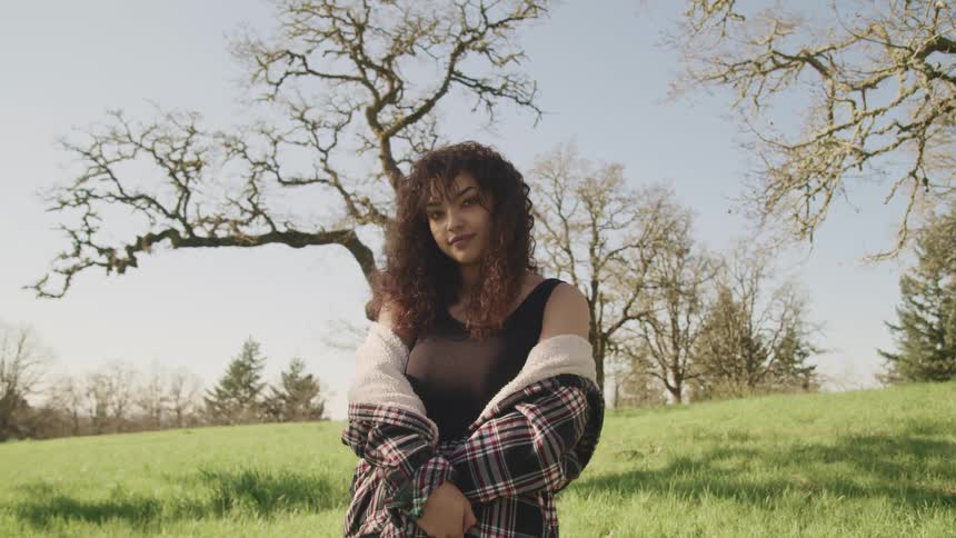 A woman is standing on the field of grass