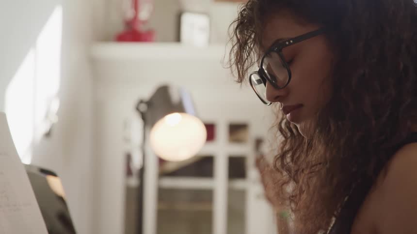 A teenage girl at home sits with her eyes closed