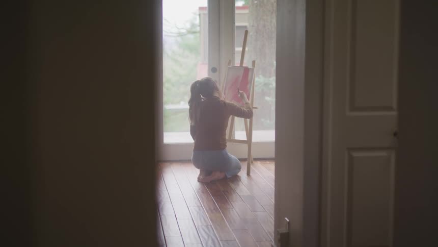 A teenage girl painting in a house