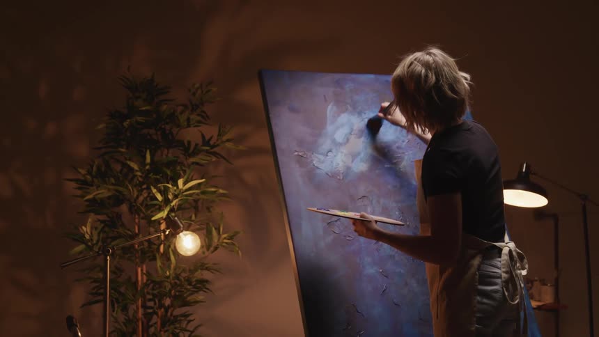 A woman is painting a picture indoors