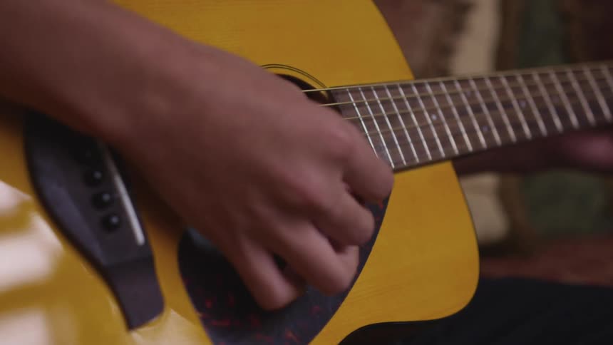 A person is playing a guitar indoors