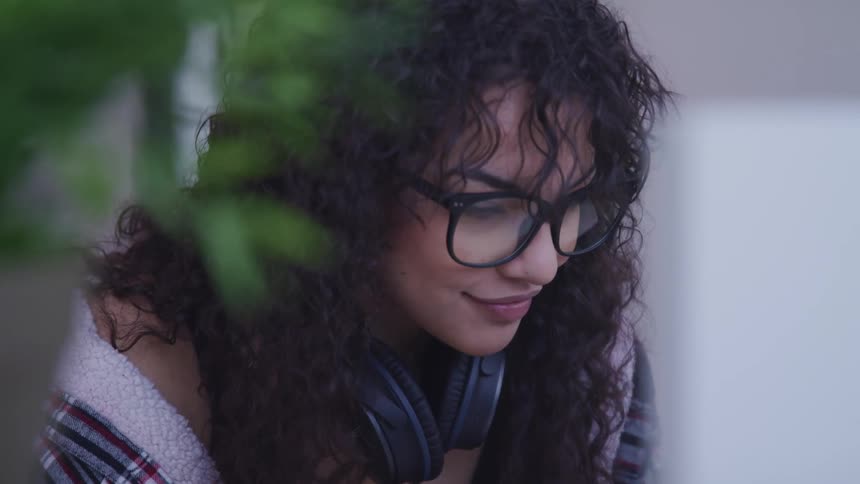 A female sitting near a laptop and reading the screen