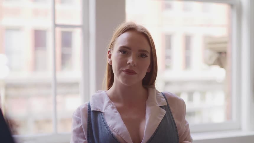 A woman is standing in a room and smiling