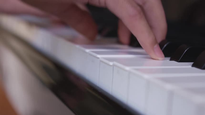 A person skillfully presses many keys as they perform a song using a piano
