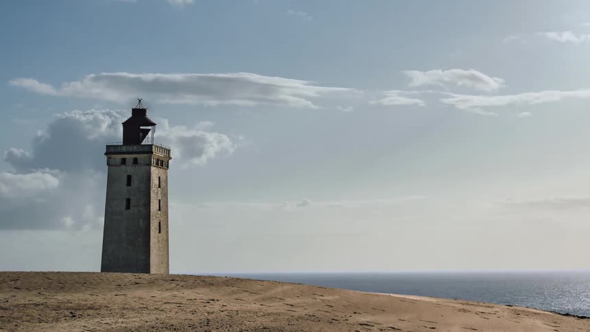 A tall lighthouse is near the water