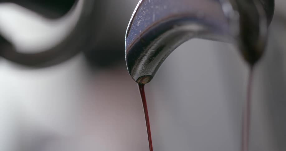 Stream of brown liquid pouring from a silver spout