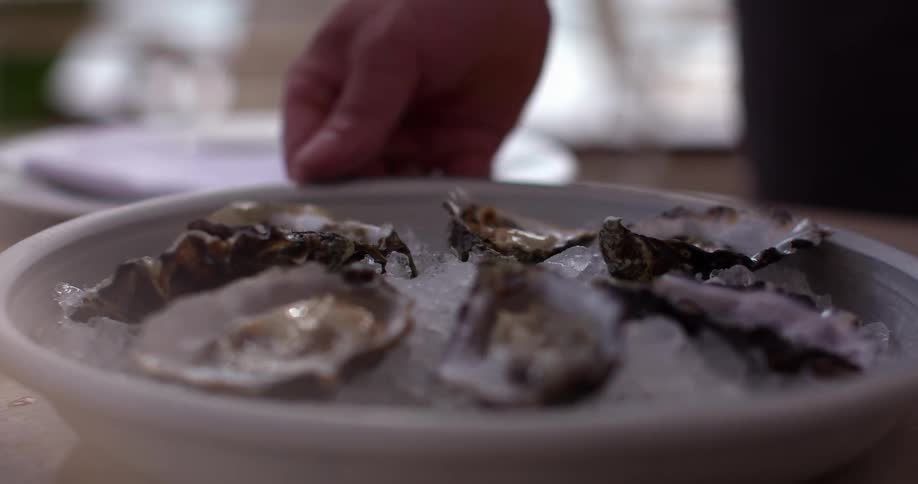 A man plates oysters at a restaurant