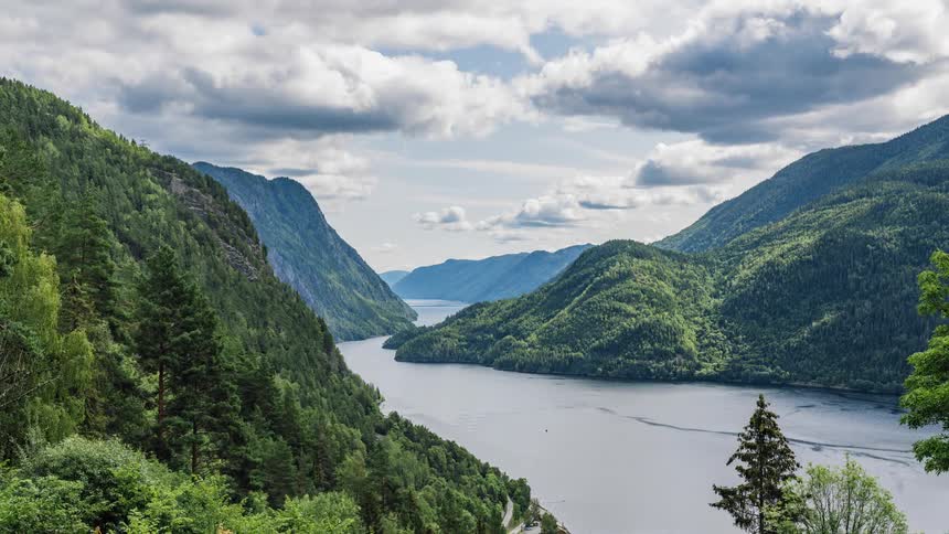 Time lapse of clouds moving over a river and forest