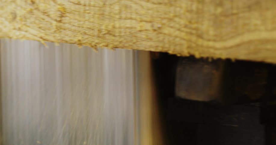 A piece of lumber is cut with a table saw
