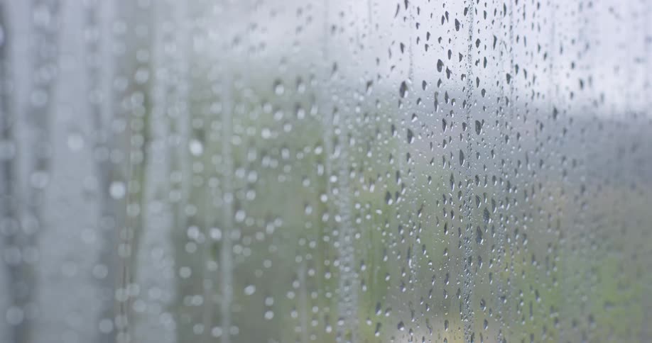 Rain drops run down a window on a rainy day