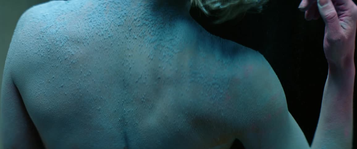 Caucasian persons bare back is covered with sand