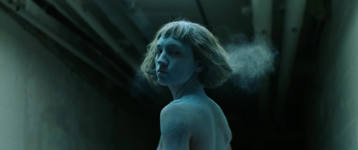 Woman covered in dust shakes her head in slow motion