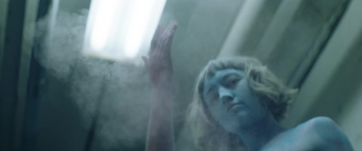 A young teenage girls covered in tattoos slaps her hands together and powder goes everywhere