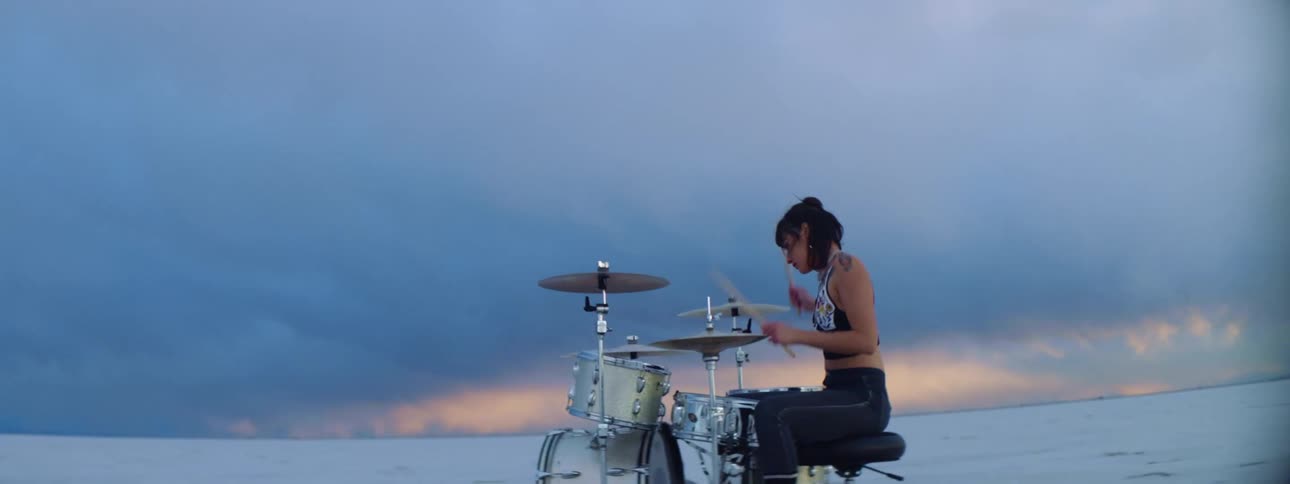 A woman is playing drums on the field