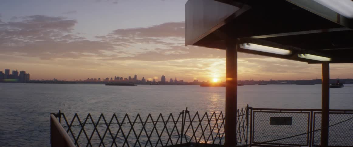 The sun is setting in the distance across the water