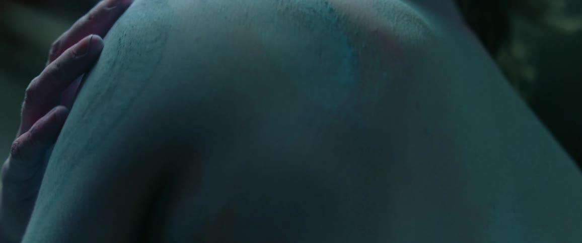 Woman draws hand down her own back disturbing layer of powder