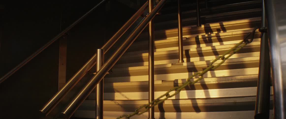 A dark staircase shows a shadow moving past