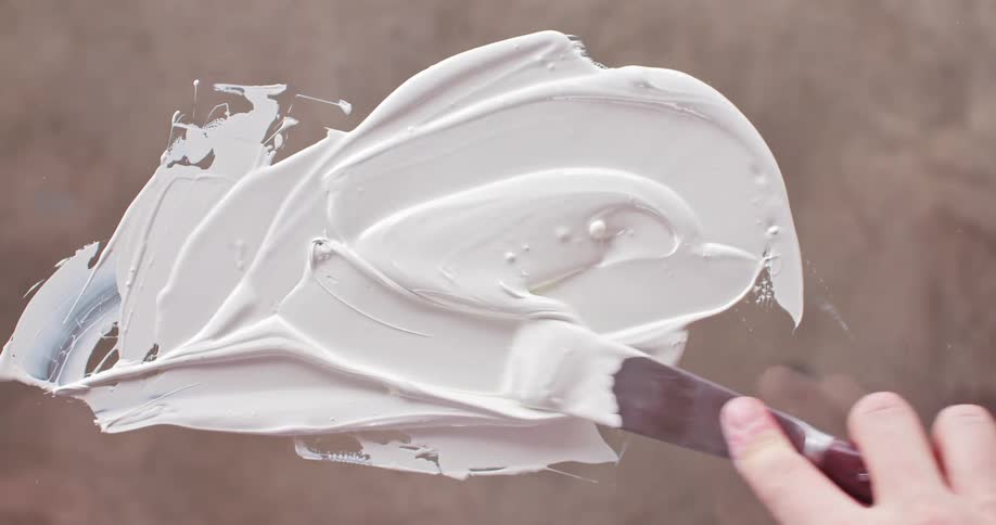 A person is mixing white paint