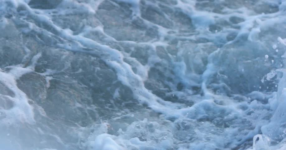 A strong wave crashes on the sand
