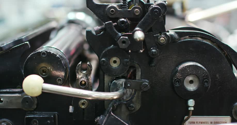 A machine with nuts and bolts and rollers moving