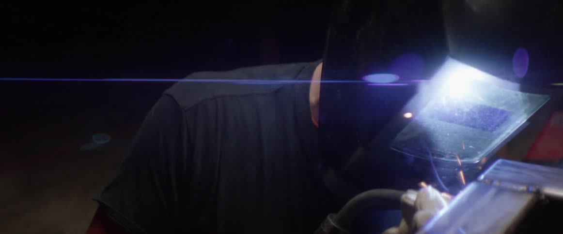 A welder works with sparks flying around