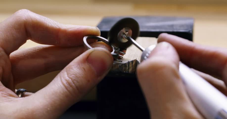 Jeweler uses a grinder on the claws of a ring
