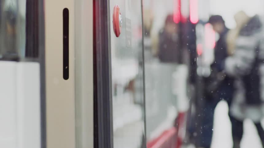 People get on the bus as it snows