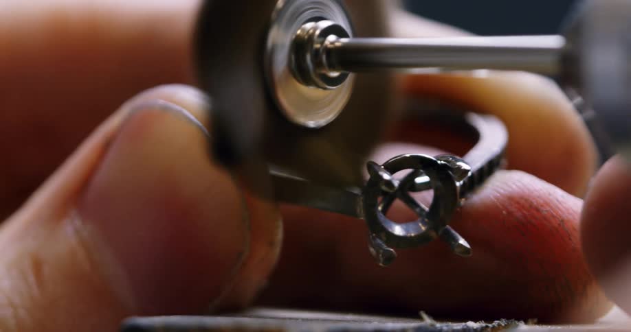 A jeweler polishes a ring before setting it