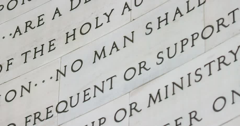 Text written in black on a stone wall of a building or monument