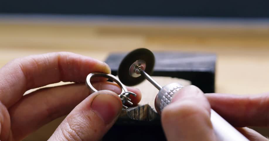 A jeweler shapes a ring with a tool