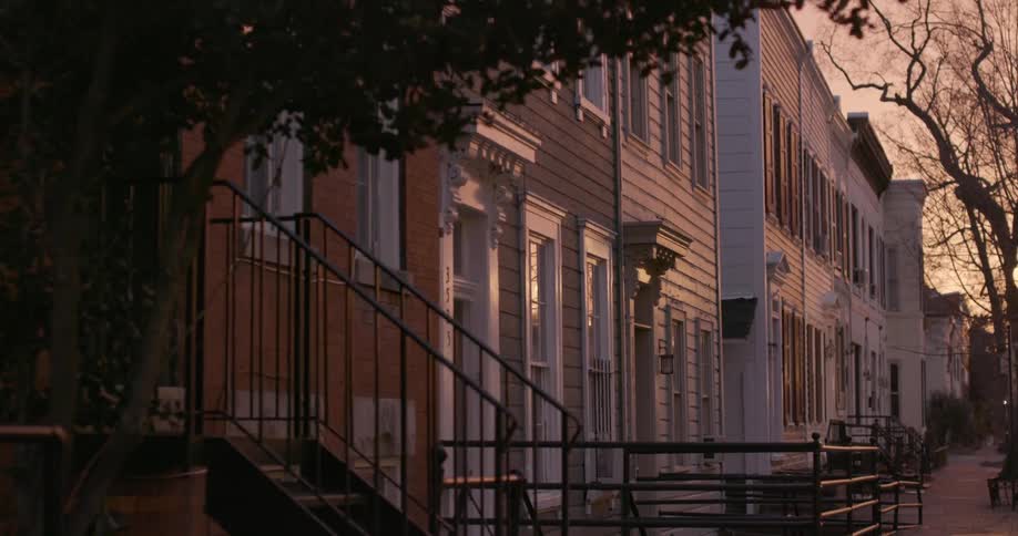 A row of townhouses in a city neighborhood at sunset