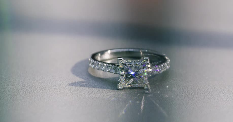 Diamonds sparkle and gleam from within this wedding ring sitting on flat surface