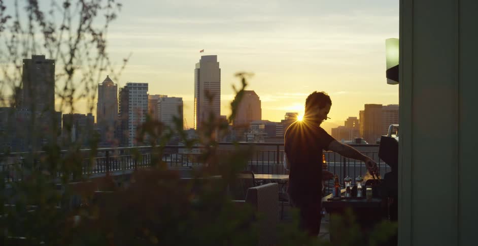 A man is grilling on his terrace on the building