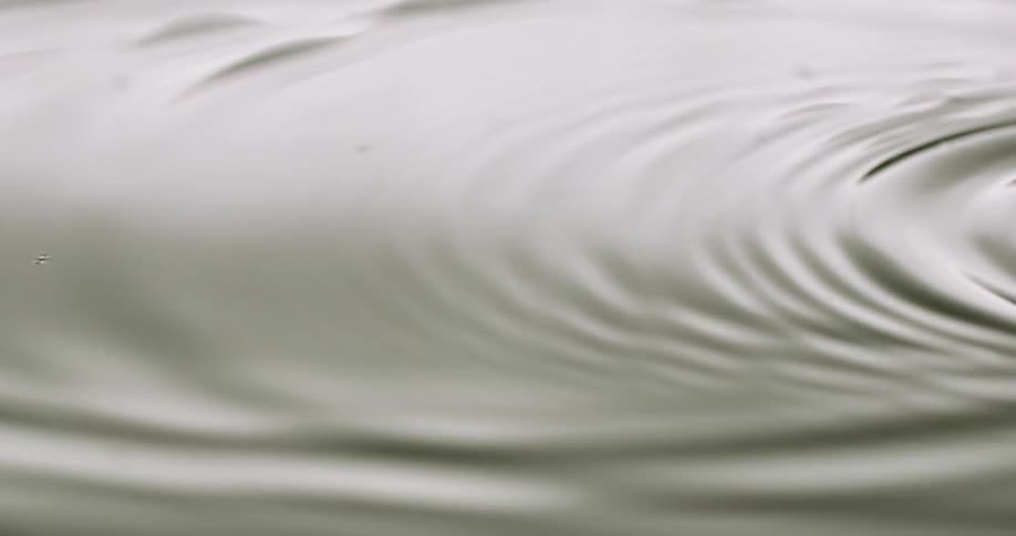 Droplets of water falling in water and causing ripples