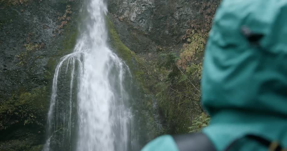 A person is outdoors by a waterfall
